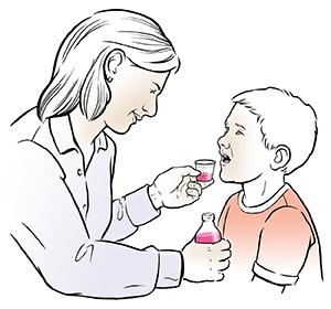 Woman giving liquid medication to boy.