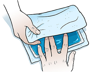 Closeup of hands wrapping ice pack in thin towel.