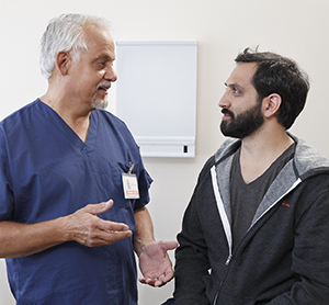 Patient in exam room talking to health care provider.