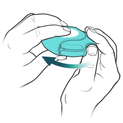 Thumb pushing on thumb grip on side of inhaler.
